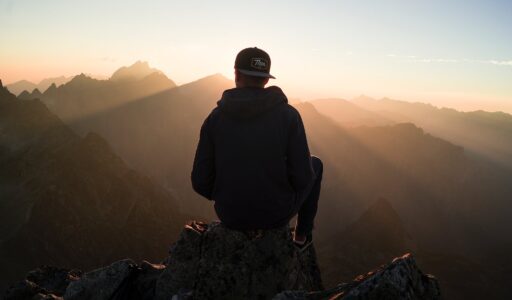 man sitting on the mountain edge