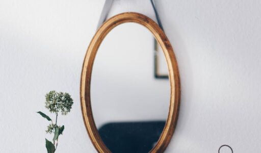 oval brown wooden framed hanging mirror