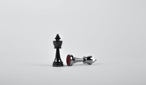 two silver chess pieces on white surface