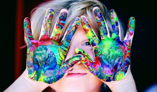 a kid with multicolored hand paint